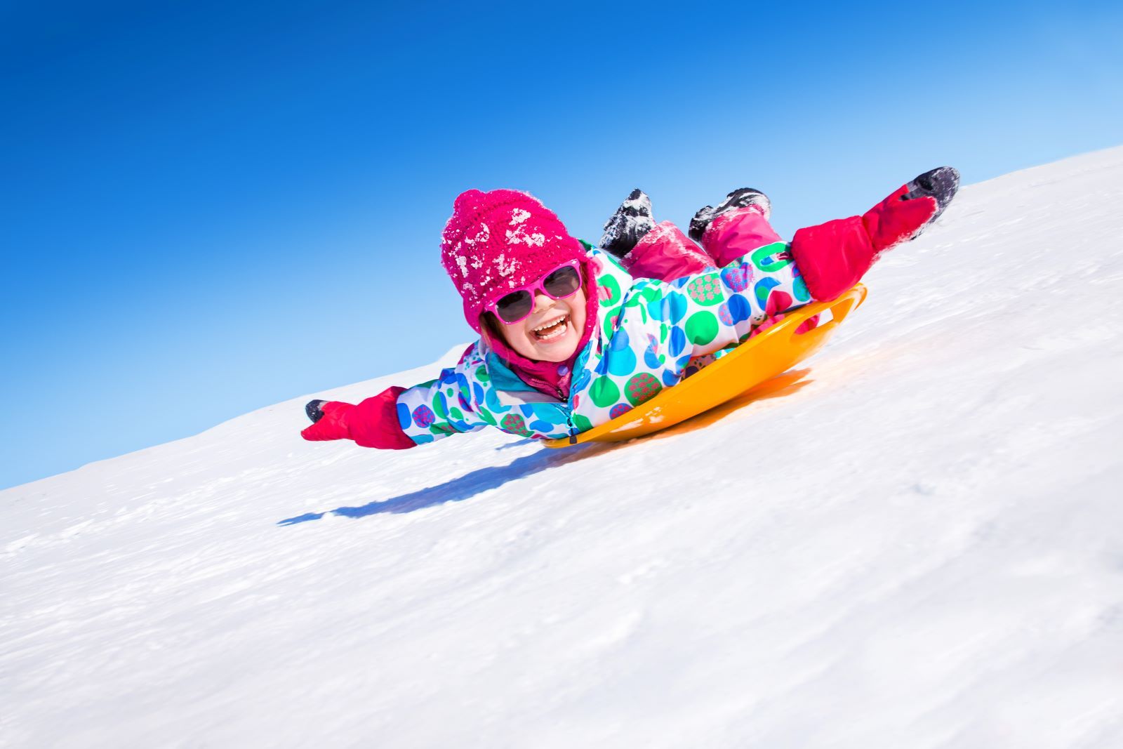 kid sledding in snow